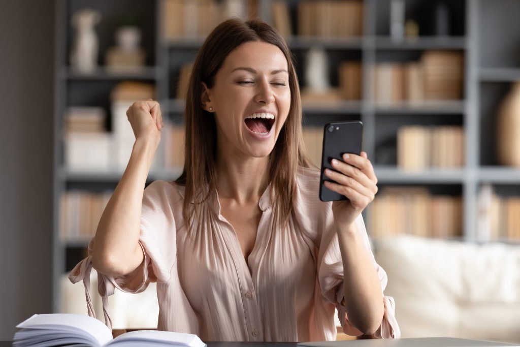 Close Up Overjoyed Woman Looking At Phone Screen Celebrating Success